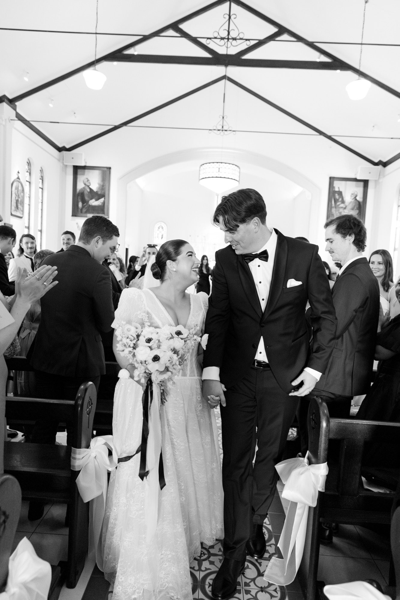 The newly married couple laughing as they walk back down the aisle, St Luke's Church
