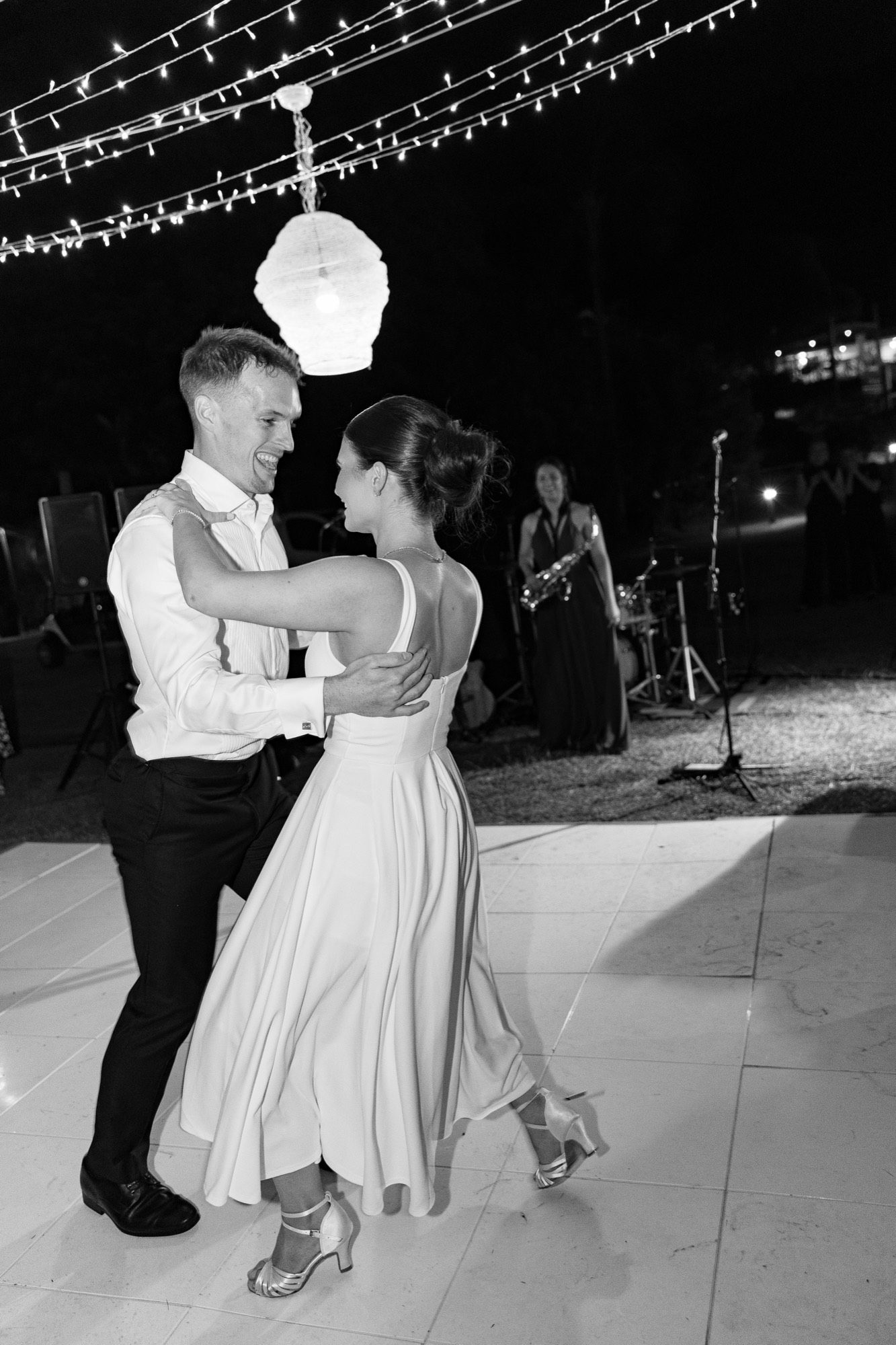 First dance under festoon lights with a saxophonist playing, Freedom Shores, Airlie Beach